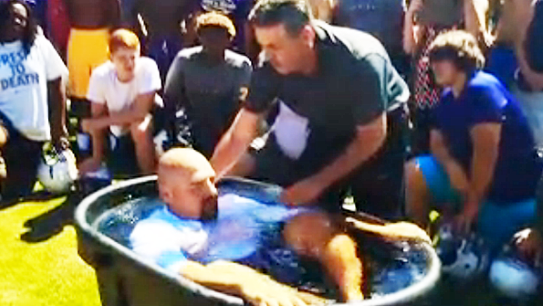 A video that was posted on YouTube shows staff members and students at Villa Rica High School taking part in a baptism ceremony before football practice