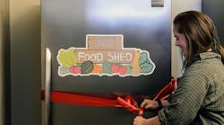 Hannah DePorter cuts a ribbon at the grand opening of the UW Campus Food Shed.