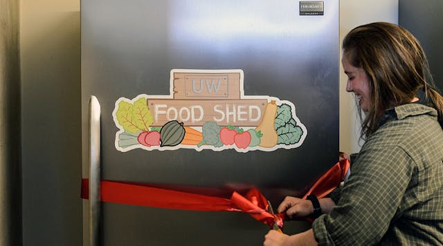 Hannah DePorter cuts a ribbon at the grand opening of the UW Campus Food Shed.