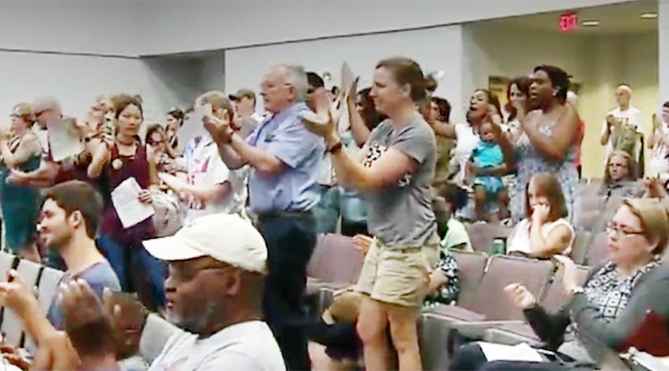 Patrons in the Orange County (N.C.) district applaud after school board approves student dress code.