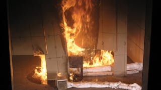 This photograph is from a commissioned test of HDPE untreated panels conducted by an independent laboratory using the NFPA 286 room-corner test. The photo shows the HDPE panels being tested as they would be installed as toilet partitions in the field. Note the resulting flammable liquids fire on the floor and flammable liquids &ldquo;flow&rdquo; on the panels.