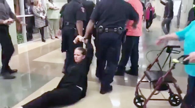 Police drag a patron out of a board meeting in the Houston school district.