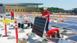 Workers install solar panels at the Truax campus of Madison Area Technical College
