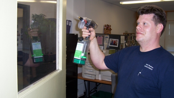 A staff member at East Meadow School District uses a green product to clean a door in this 2009 file photo East Meadow is a previous Green Cleaning Award winner