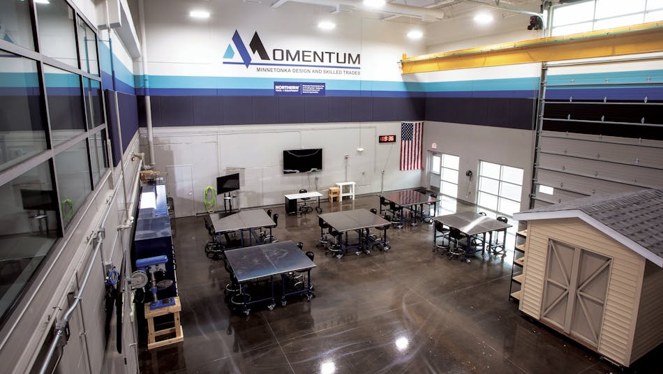 There appears to be a three-dimensional printer in the image of a "Modern office or classroom with a 3D printer".