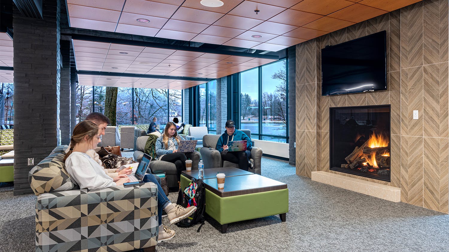 Students engaging in study break in lounge by fireplace