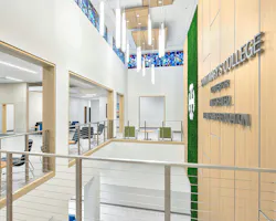 Large atrium space with wood wall and chandelier at entrance to health science building