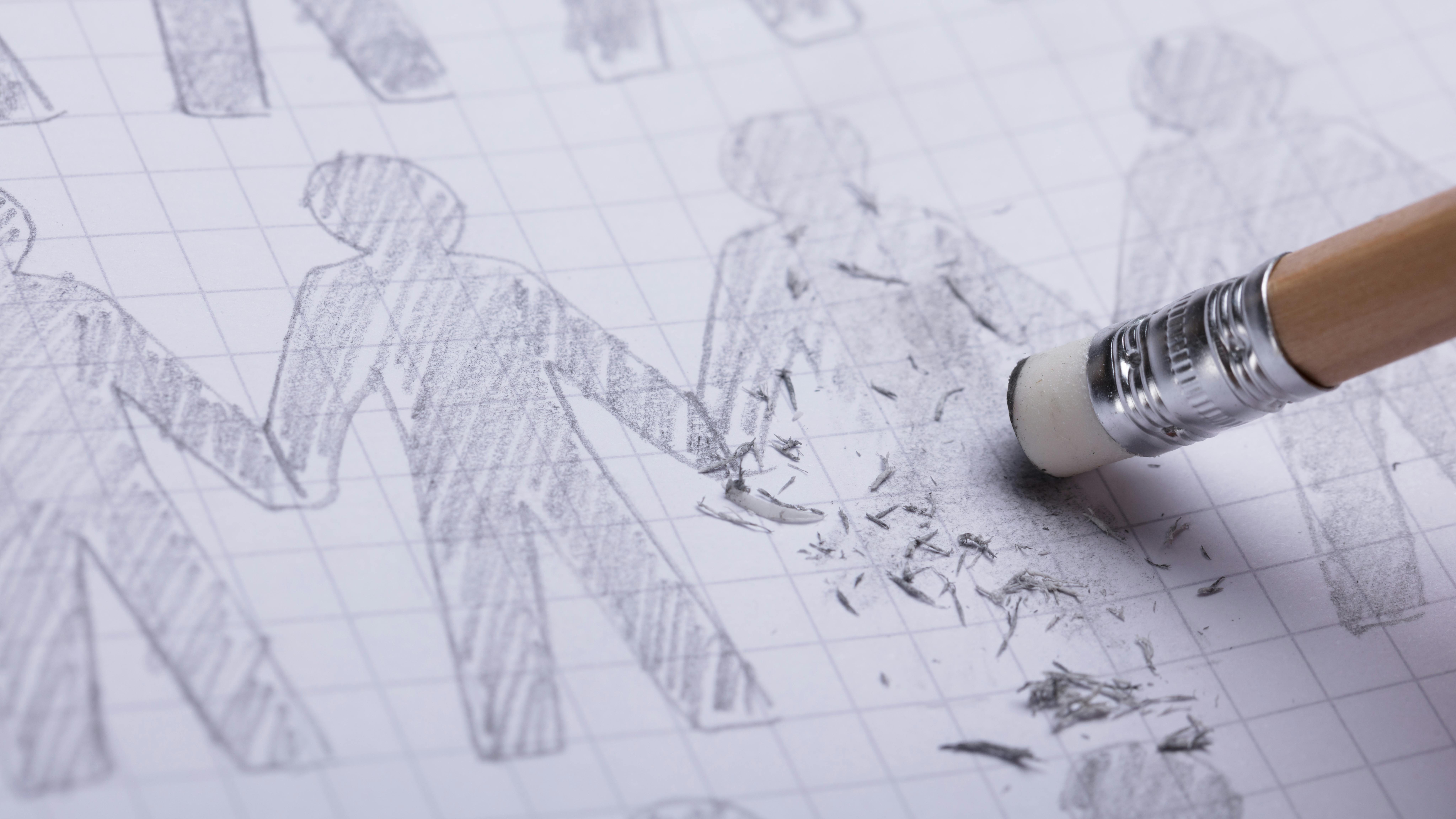 Close-up Of Pencil Eraser Erasing Drawn Human Figures On Paper