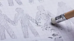 Close-up Of Pencil Eraser Erasing Drawn Human Figures On Paper