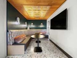 Common space with contemporary finishes, bench seating, and audiovisual equipment in the Berkeley Building
