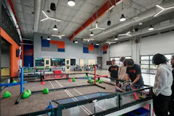 Students work on various STEM and robotics projects at test tables and computer workstations