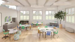 A spacious classroom configuration with trapezoidal student desks arranged in small clusters, with a curved teacher workstation, in neutral tones complemented by shades of mint green, pastel lilac, and goldenrod yellow