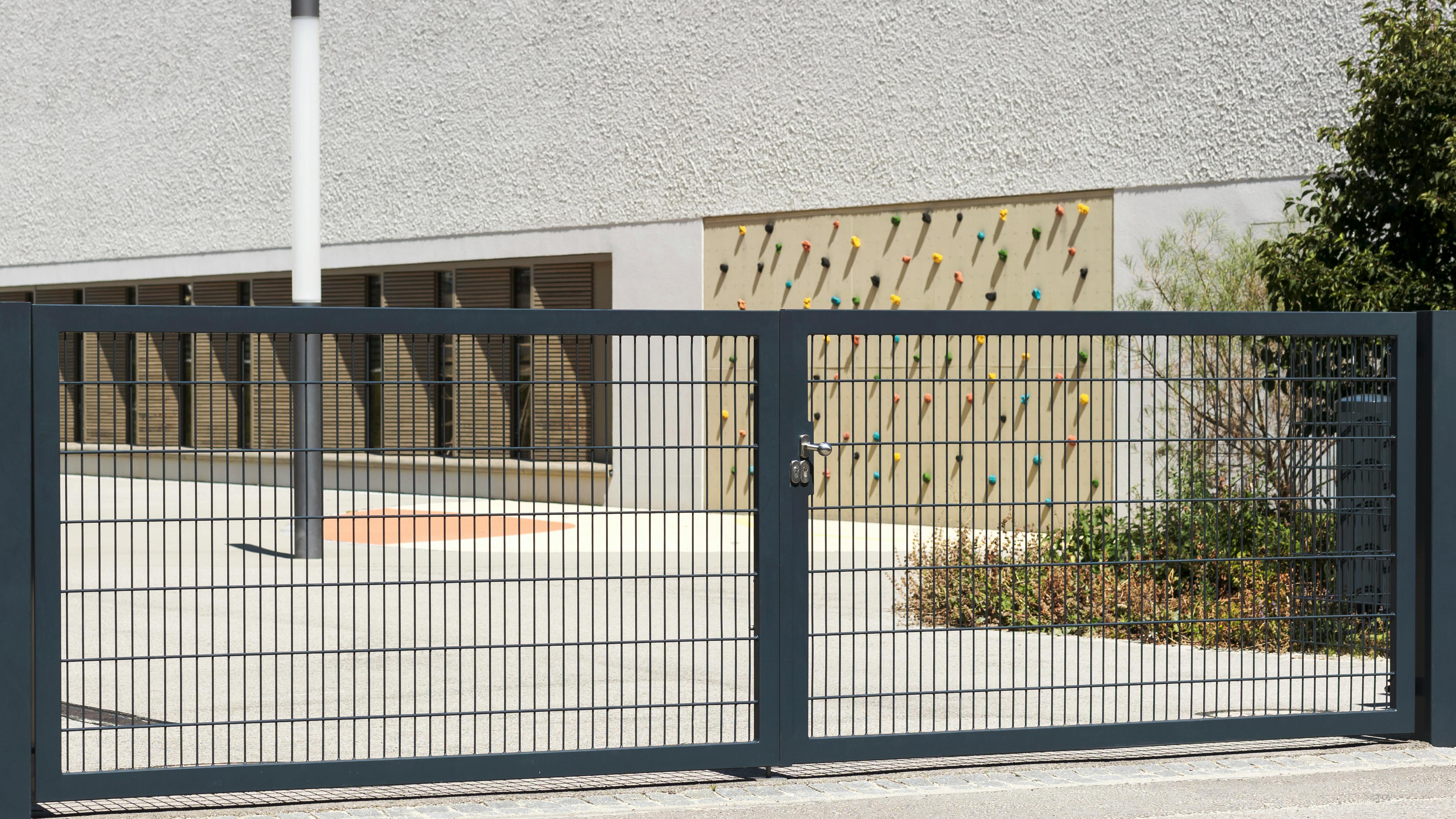 Automated security gate in front of empty playground of school.