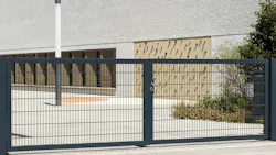Automated security gate in front of empty playground of school.