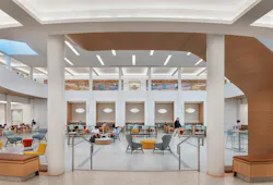 Interior of contemporary, two-story atrium student success center with lounge seating.
