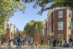Exterior of historic building at UVA with students walking and biking.