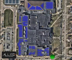Aerial view of photovoltaic panels on roof of high school.