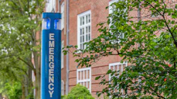 Close-up of blue emergency station at university campus.