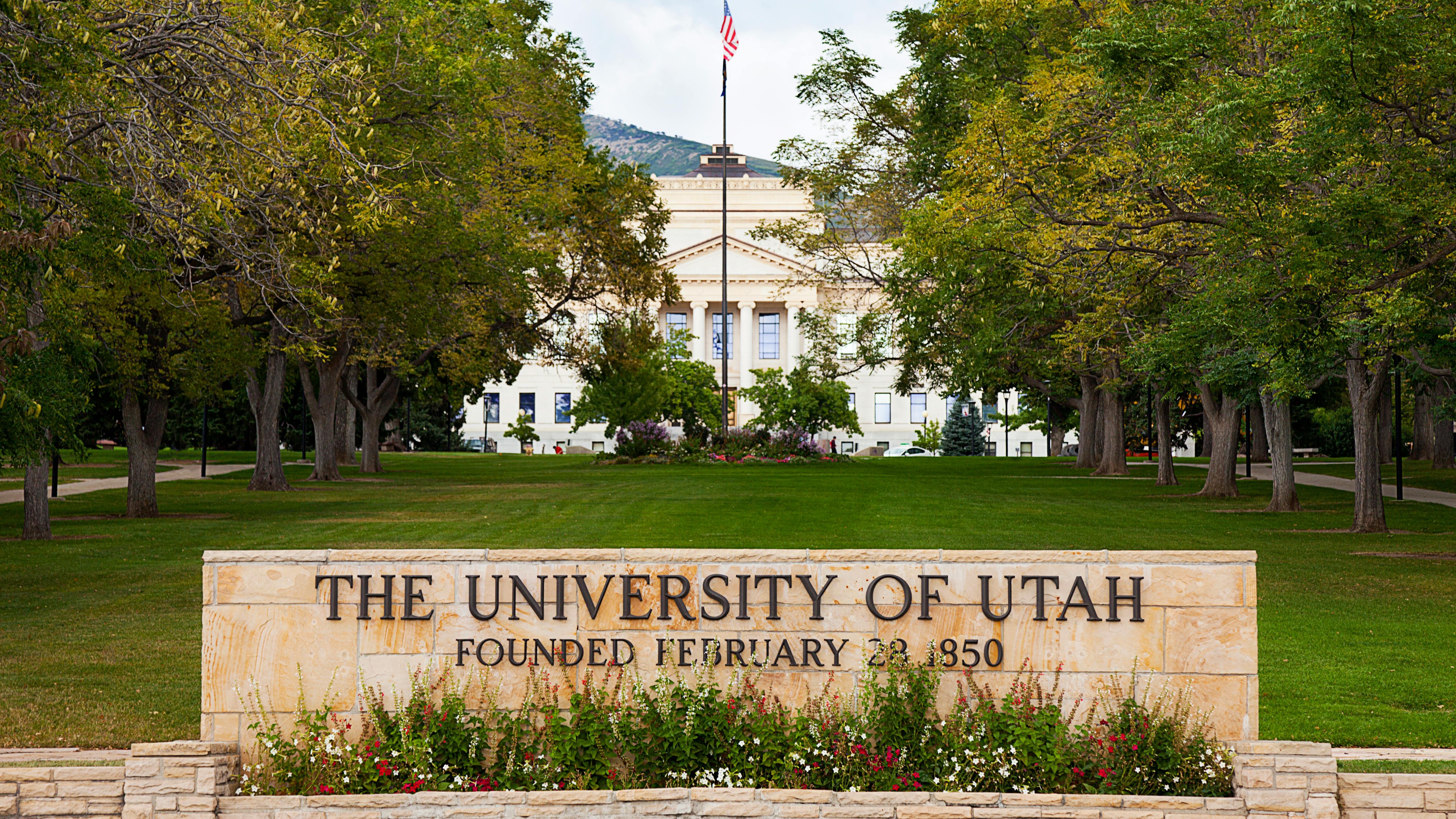 University of Utah Presidents' Circle Entrance sign with trees and building in background.