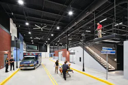 Large industrial complex simulating streetscape with EMT vehicle and people pushing a gurney.