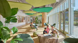 Daylit seating area with students reading among plants and biophilic acoustic ceiling panels in the shape of plants.