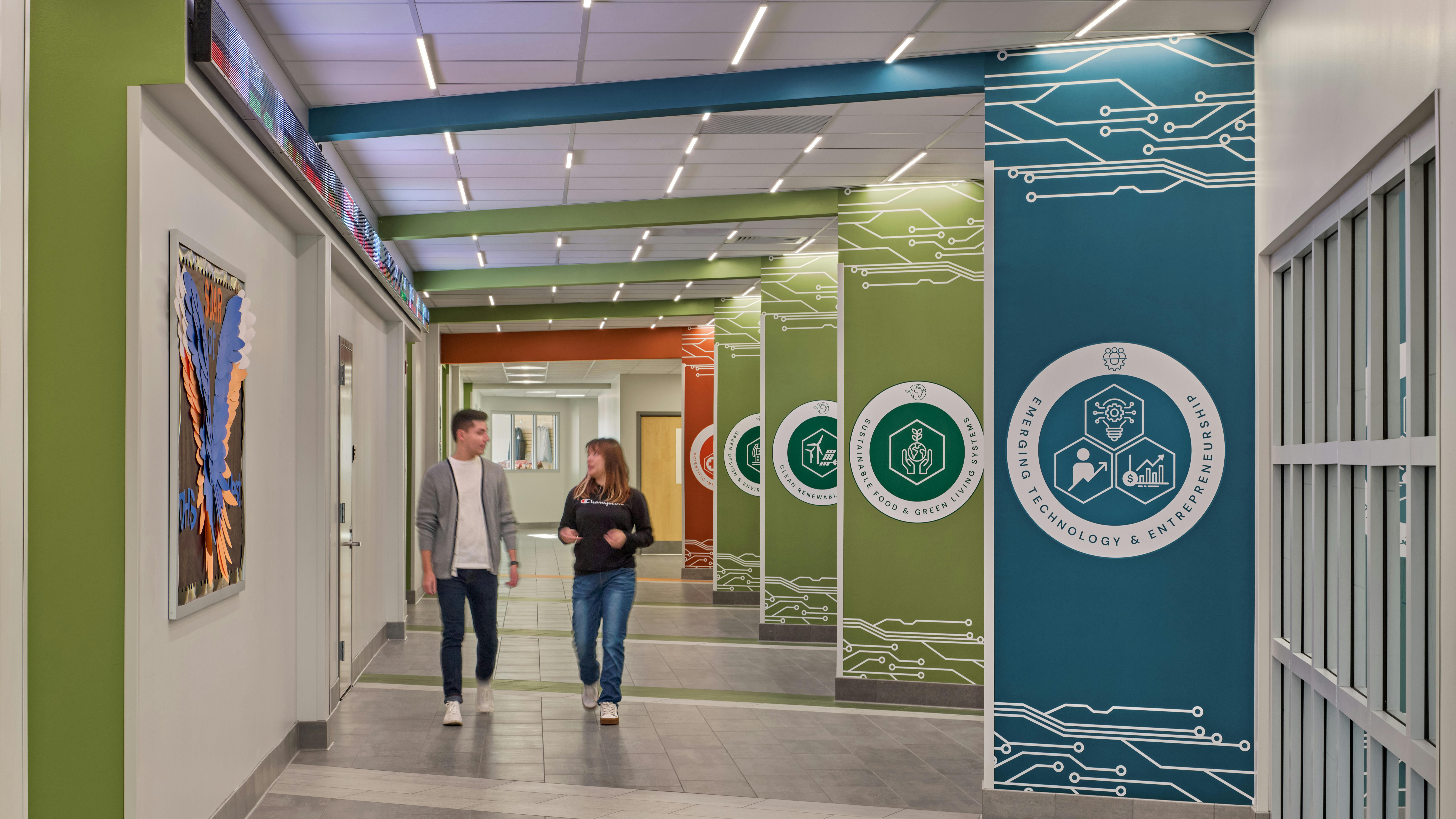 Two students walk down hallway of new school.