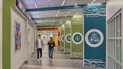 Two students walk down hallway of new school.