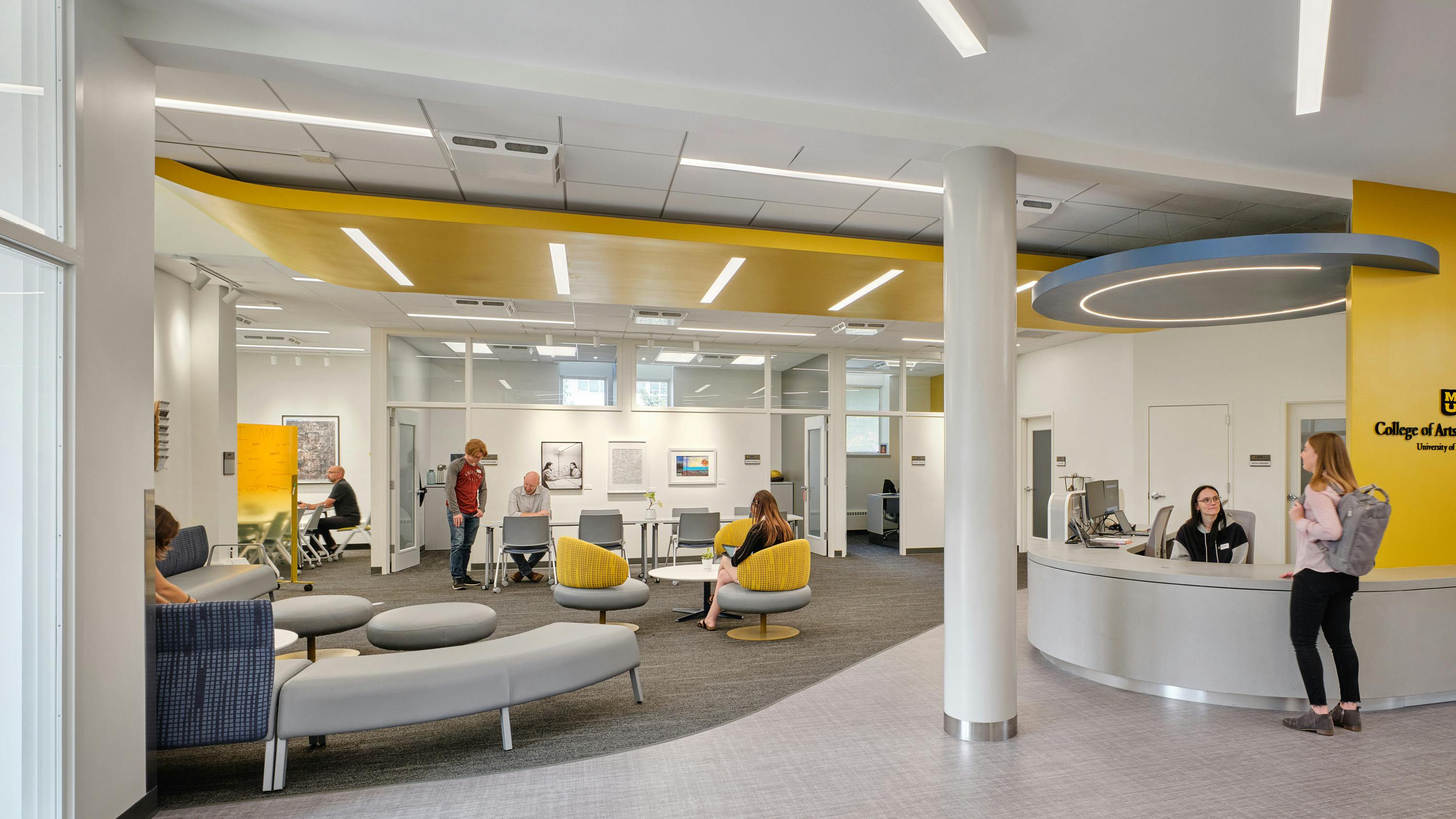 Bright, colorful reception and lounge area with students and staff engaging.