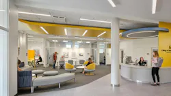 Bright, colorful reception and lounge area with students and staff engaging.