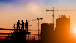 Silhouette of construction workers on construction site at dusk.