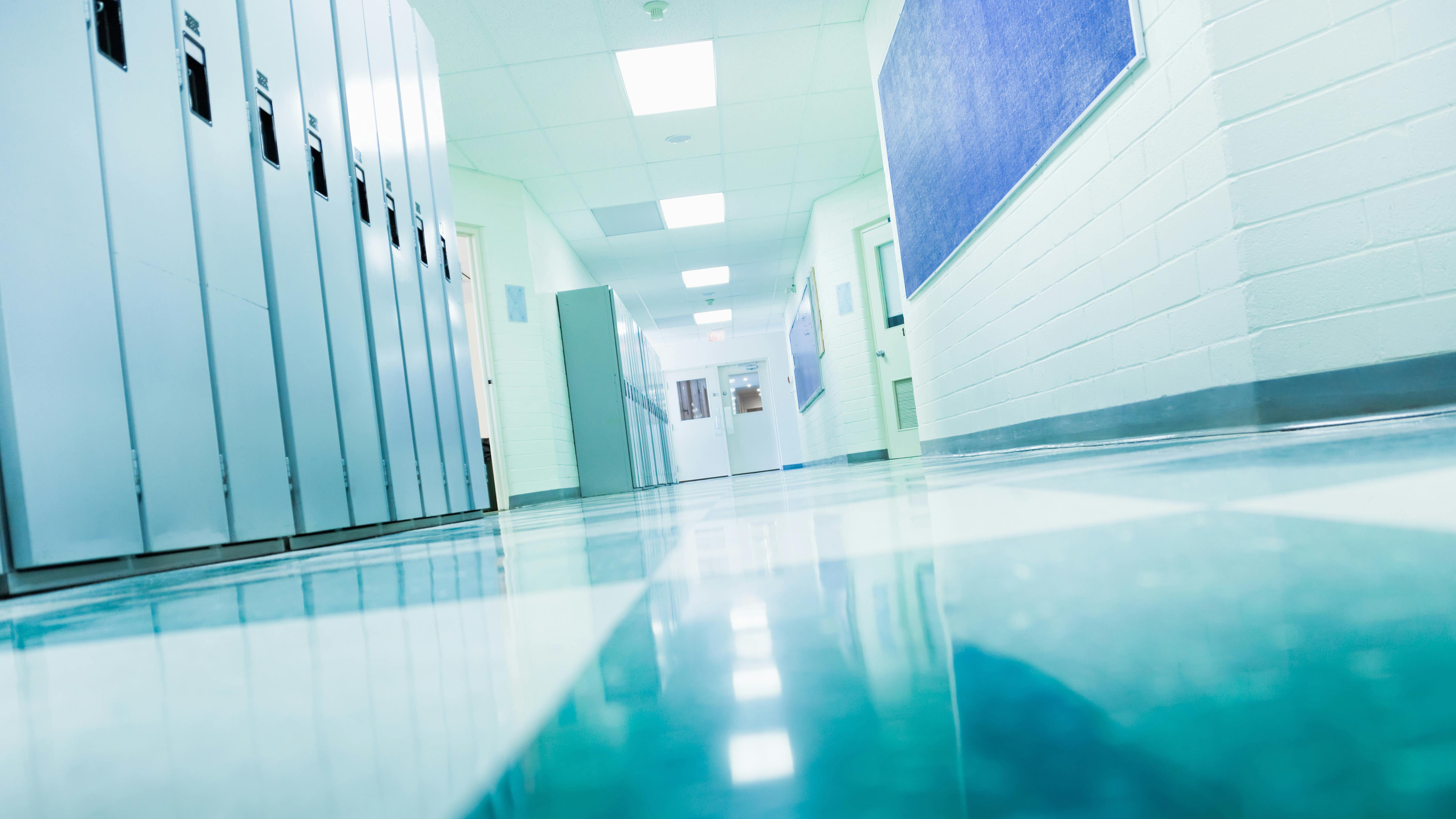 Empty college school hallway with lockers, low angle view from floor.