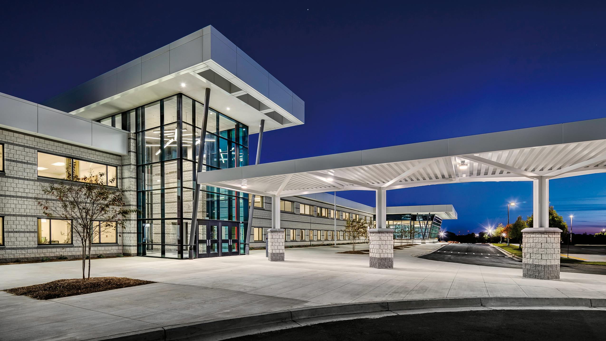 Exterior view of Jonesboro High School at dusk with lights on.