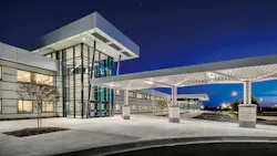 Exterior view of Jonesboro High School at dusk with lights on.