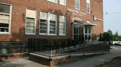 Exterior of brick building housing Durham County School office with accessibility ramp leading to entrance.