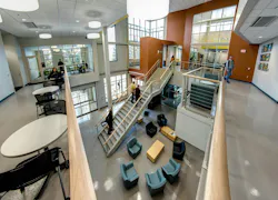 Large two-story atrium with lounge seating next to staircase.