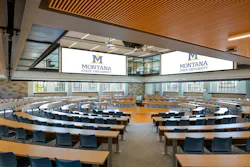 Large classroom with tables and chairs configured in a circular pattern.