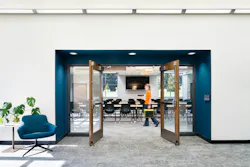 Double doors open to classroom with tables and chairs.