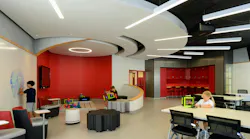 Modern classroom with variety of seating areas, writable walls, and oculus-shaped ceiling with lighting fixtures extending outward.
