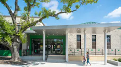 Parent and child walk under covered entrance to newly remodeled elementary school.