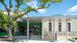 Parent and child walk under covered entrance to newly remodeled elementary school.