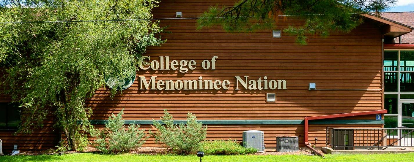 Exterior of wood building with landscaping at the College of Menominee Nation college.