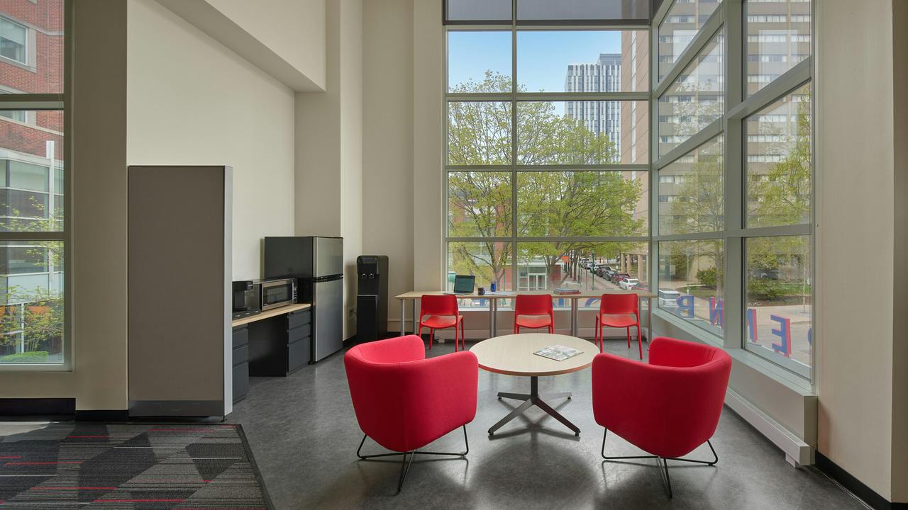 Lounge area with comfortable, contemporary seating next to floor-to-ceiling windows.