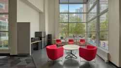 Lounge area with comfortable, contemporary seating next to floor-to-ceiling windows.