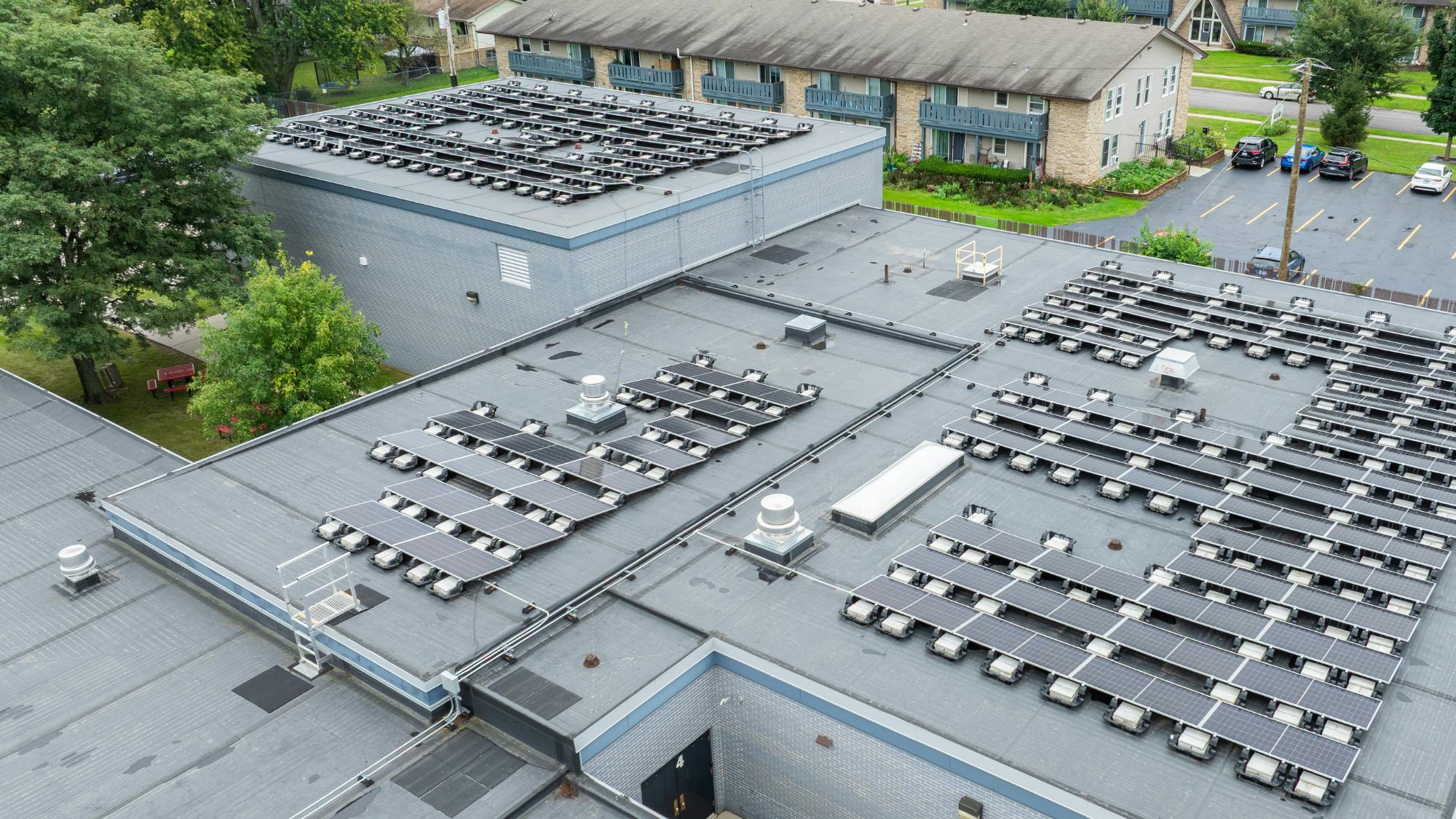 Aerial view of solar rooftop array on top of school building.