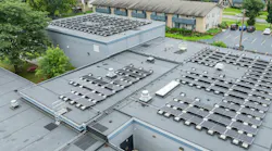 Aerial view of solar rooftop array on top of school building.