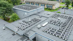 Aerial view of solar rooftop array on top of school building.