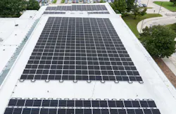 Aerial view of solar array on school building rooftop.
