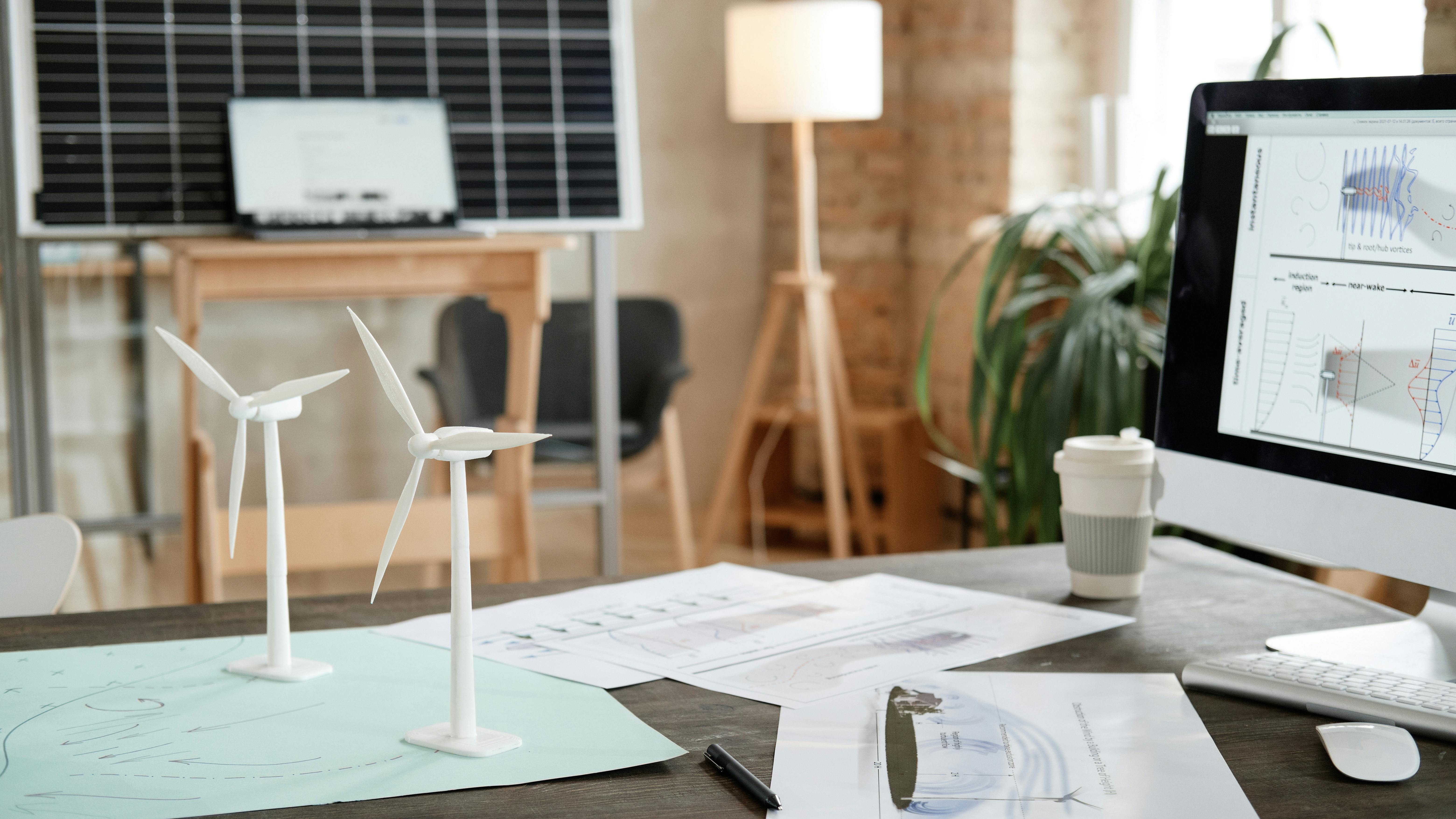 Image of workplace of architect with computer monitor blueprints and design models at office