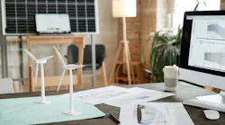Image of workplace of architect with computer monitor blueprints and design models at office