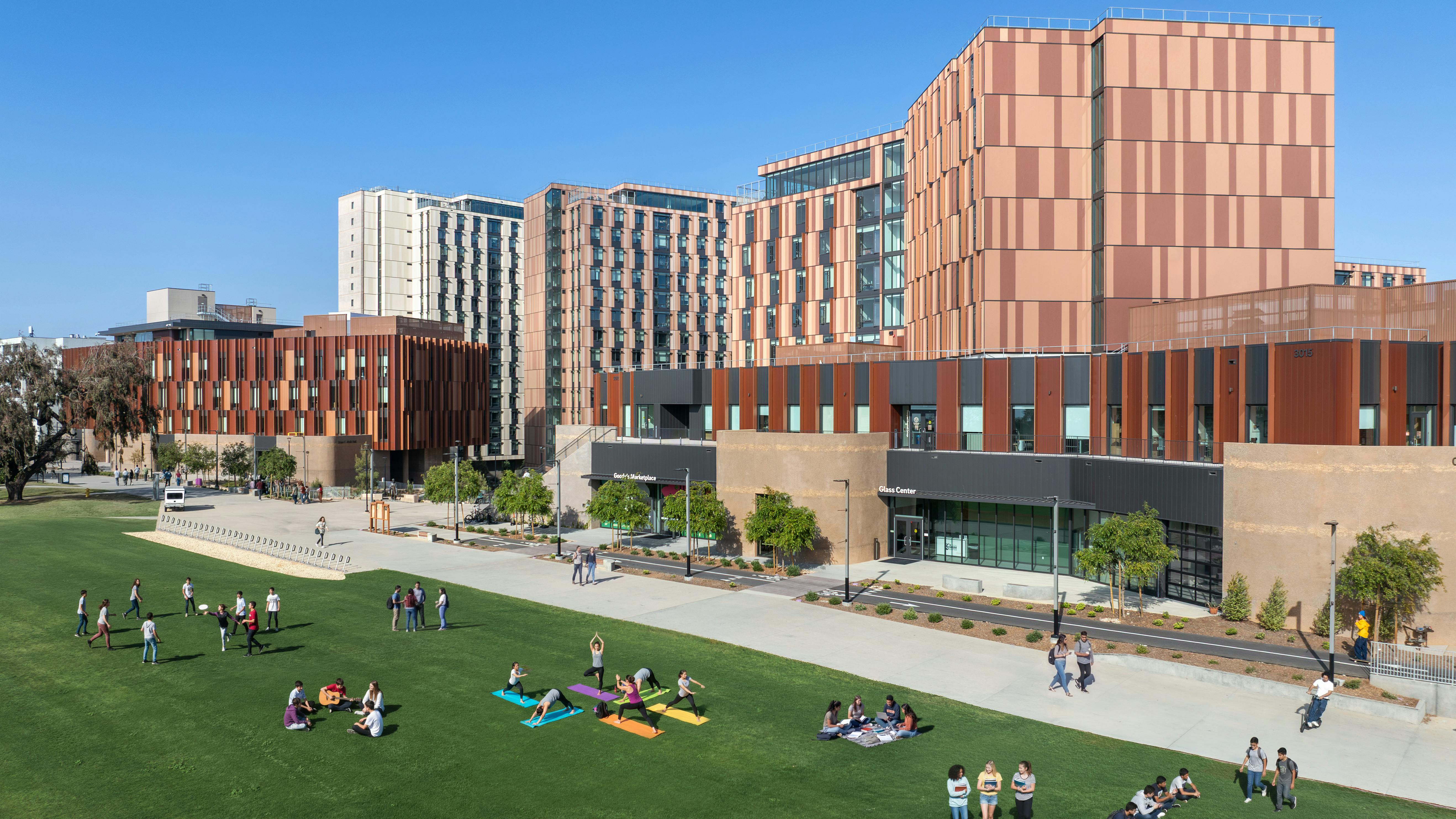 Aerial view of new mixed-use student residence hall and classroom buildings above lawn space.